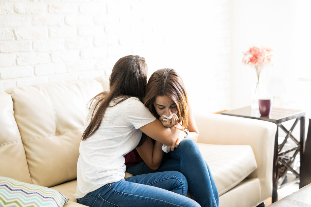 Woman comforting crying friend