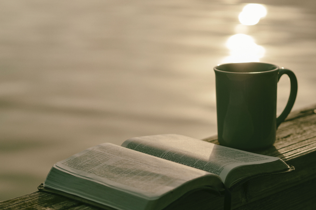 A mug next to an open bible