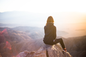 woman sitting on top of a mountain